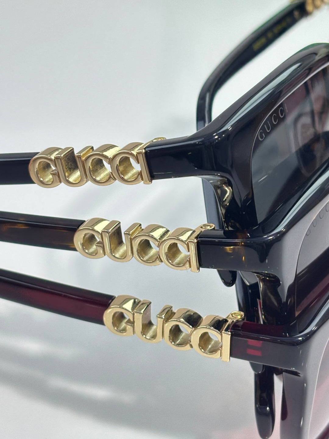 Black sunglasses with gold-toned decorative temple hardware and tinted lenses