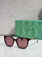 Burgundy square sunglasses with pink-tinted lenses and gold Gucci logo on temples