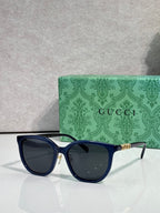Navy square sunglasses with dark lenses and gold Gucci logo on temples