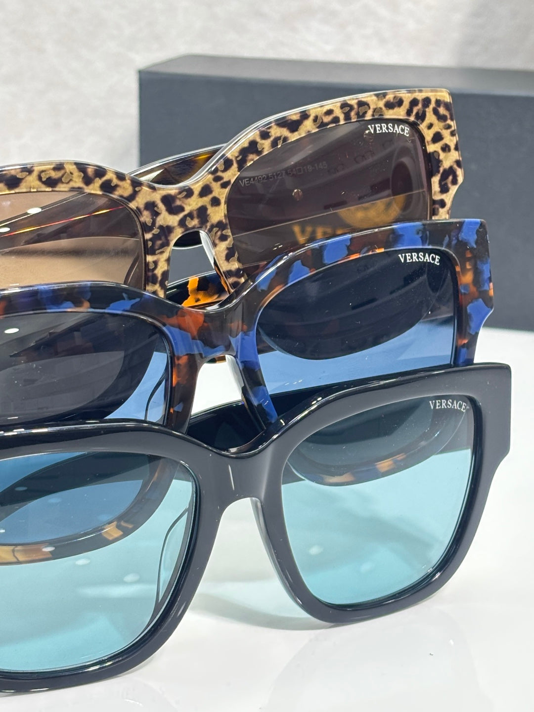 Versace sunglasses with leopard and blue frames, gold “101” logo on temples.
