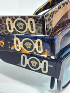 Versace sunglasses temple with leopard print and gold “101” medallion hardware.