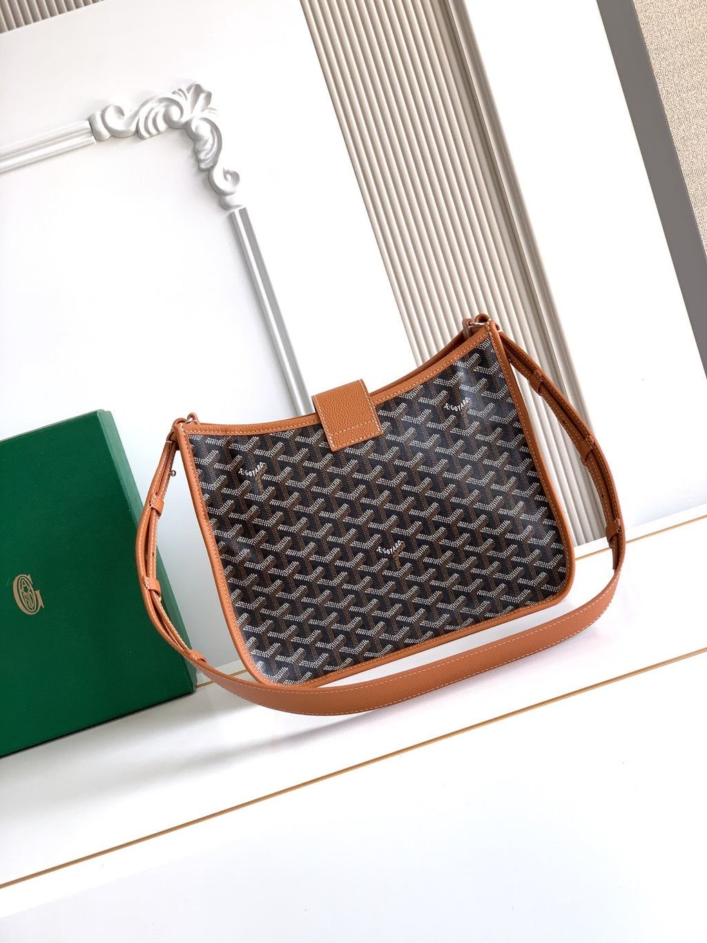 Small monogram handbag with tan leather handles and flap front, side view