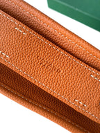 Tan leather base with contrast stitching along edge, close-up