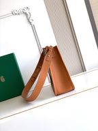 Leather bucket-style bag with shoulder strap in tan, top handles