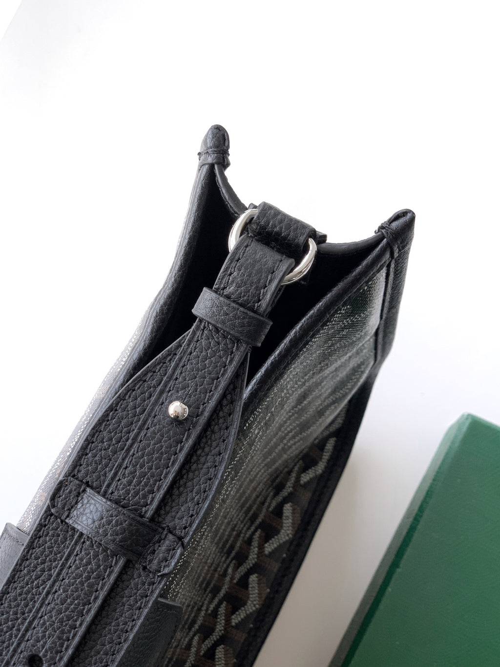 Black leather shoulder bag with side pocket opening and silver-tone hardware