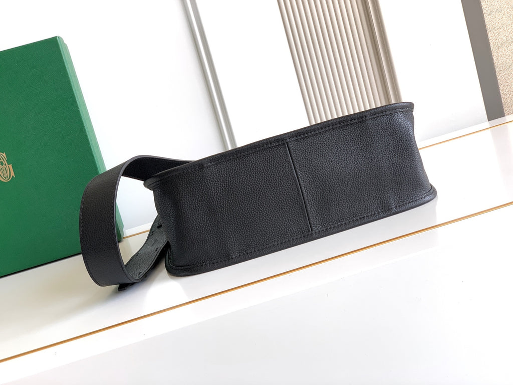 Black leather strap bag with wide strap and snap-closure front