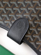 Black leather clasp detail on patterned shoulder bag with textured trim