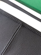 Black leather bag panel with visible seam and textured grain detail