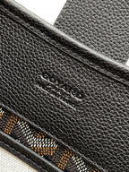 Black leather bag exterior with embossed logo detail and patterned trim