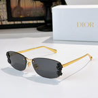 Dior sunglasses with gold frame, dark lenses, black floral temple accents.