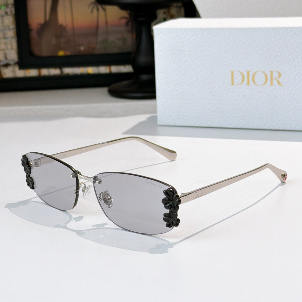 Dior sunglasses with gunmetal frame, gray tinted lenses, black floral temple details.