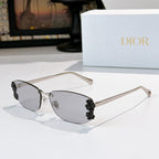 Dior sunglasses with gunmetal frame, gray tinted lenses, black floral temple details.