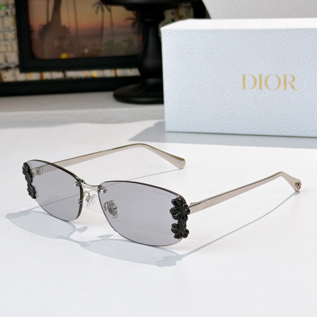 Dior sunglasses with gunmetal frame, gray tinted lenses, black floral temple details.