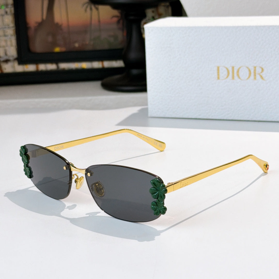 Dior sunglasses with gold frame, dark lenses, green floral temple details.