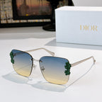 Dior sunglasses with silver-toned frame and blue-to-yellow gradient lenses, green floral accents.