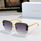 Dior sunglasses with gold frame and dark purple lenses, black floral temple accents.