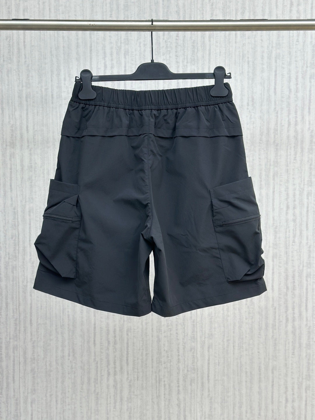 Navy cargo shorts with elastic waist, layered front, and side flap pockets