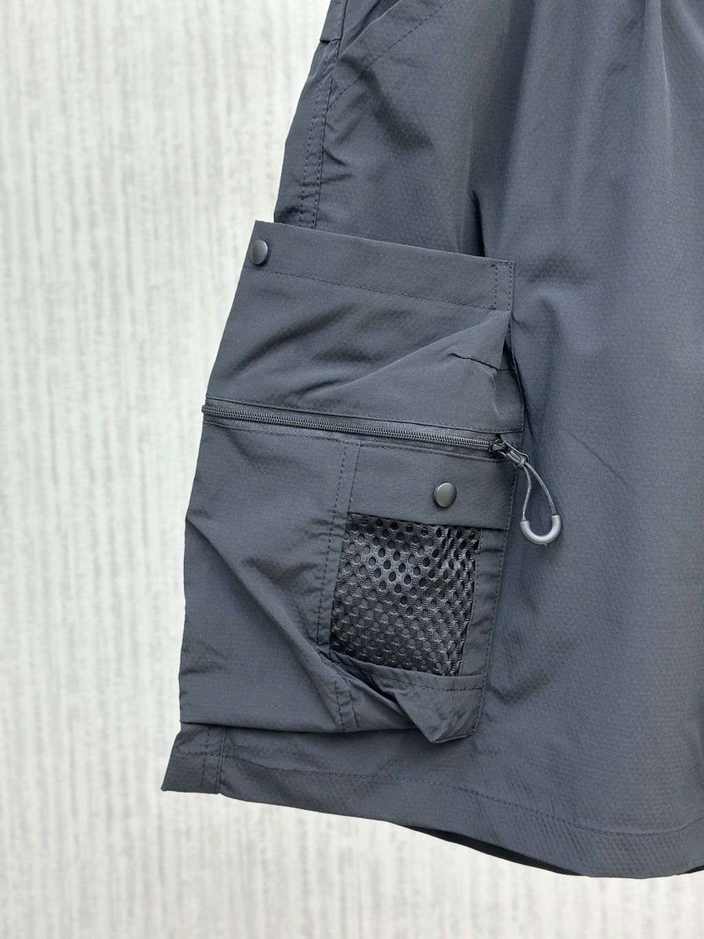 Navy cargo shorts with zippered utility pocket and mesh-lined side pocket