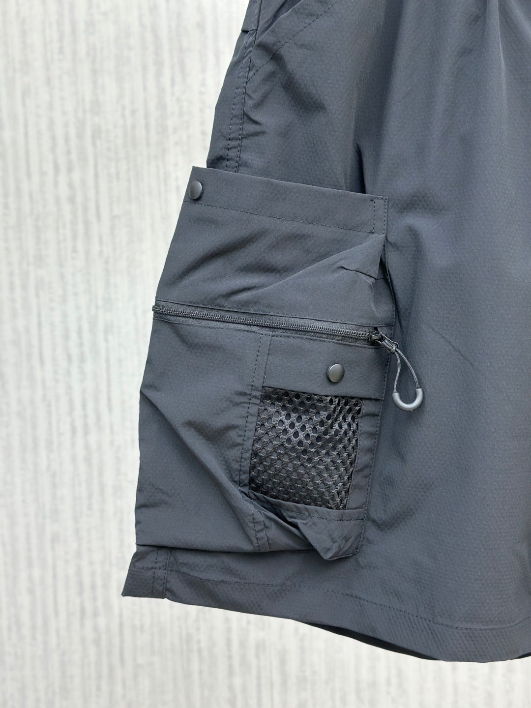 Navy cargo shorts with zippered utility pocket and mesh-lined side pocket