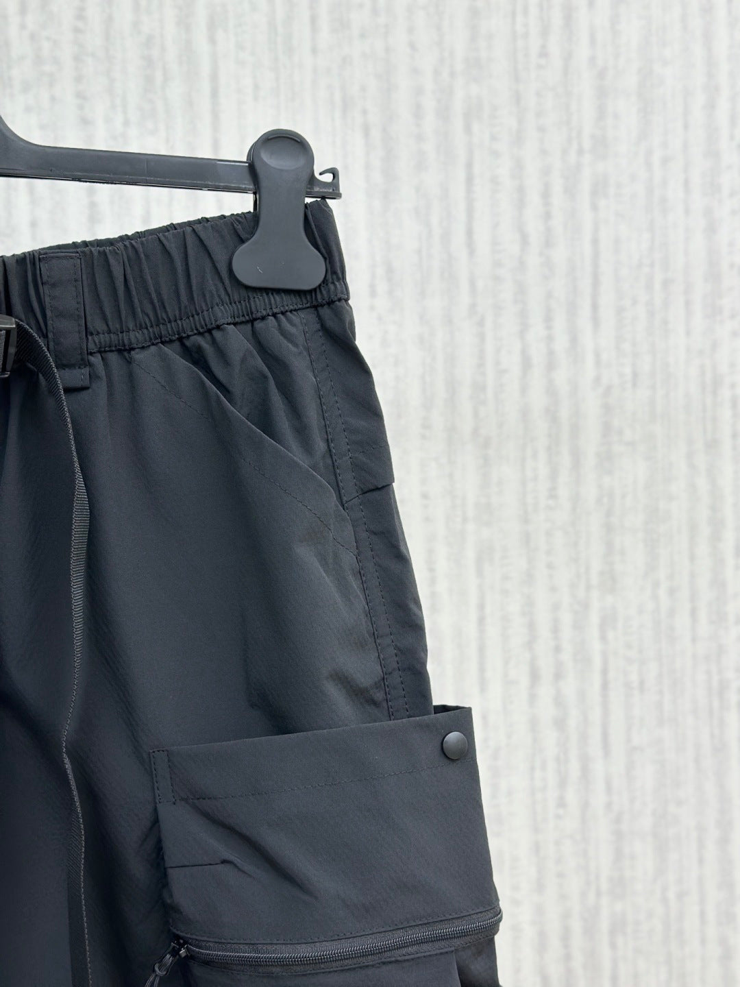 Navy cargo shorts with front button and overlapping utility pocket