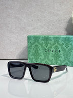 Gucci rectangular sunglasses with dark frames and dark lenses; gold GG temple logo