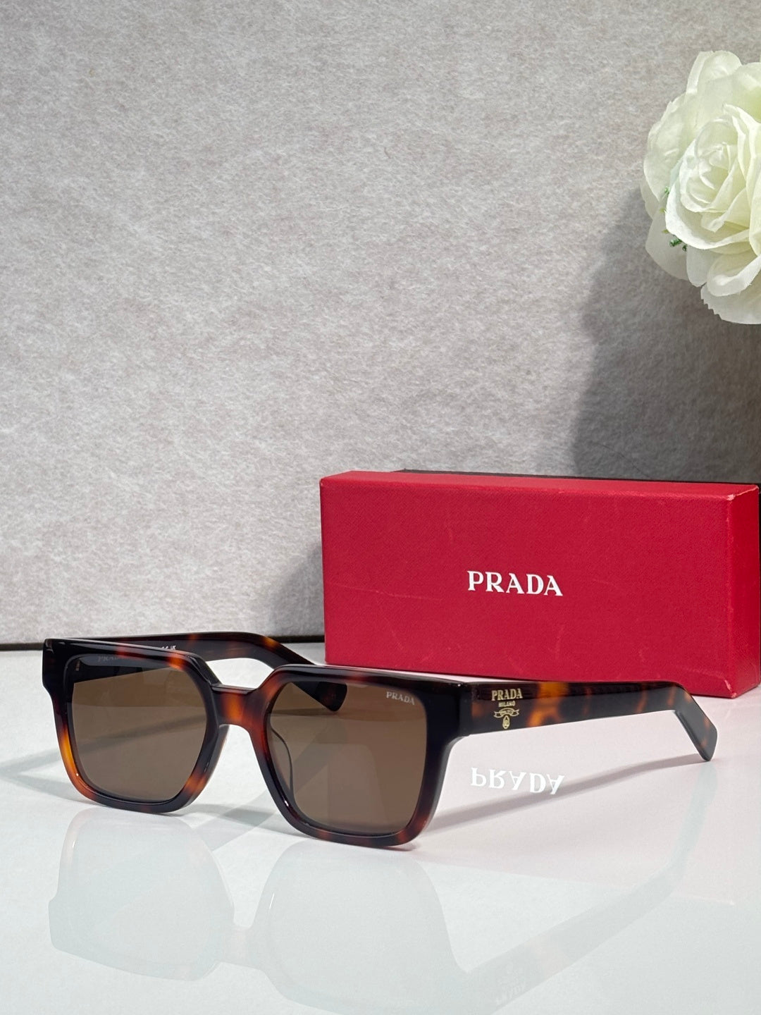 Prada tortoiseshell rectangular sunglasses with brown-tinted lenses and temple branding