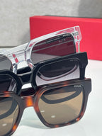 Prada tortoiseshell and black sunglasses close-up with stacked lens frames