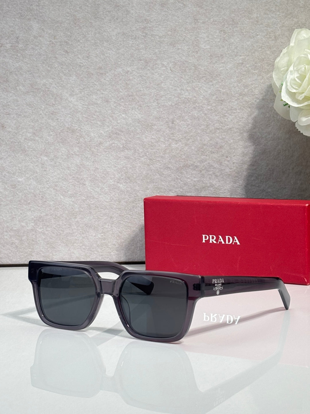 Prada black rectangular sunglasses with dark lenses and logo on the temple