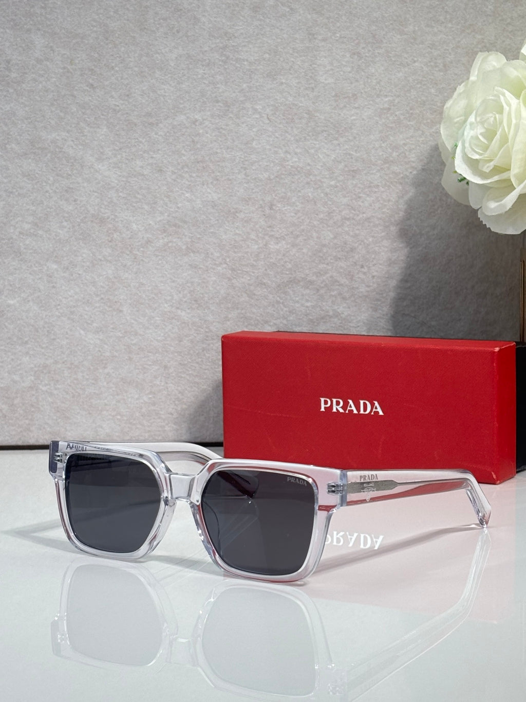 Prada clear-and-silver sunglasses with dark lenses and reflective temple details
