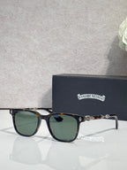 Sunglasses with dark frames and green lenses, gold-toned logo on temples.