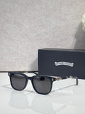 Sunglasses with dark frames and black lenses, gold-toned logo on temple.