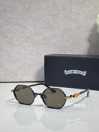 Round sunglasses with black frames, dark lenses, and gold-toned temple details