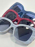 Prada square sunglasses with blue, red, and light-gray frames and dark lenses