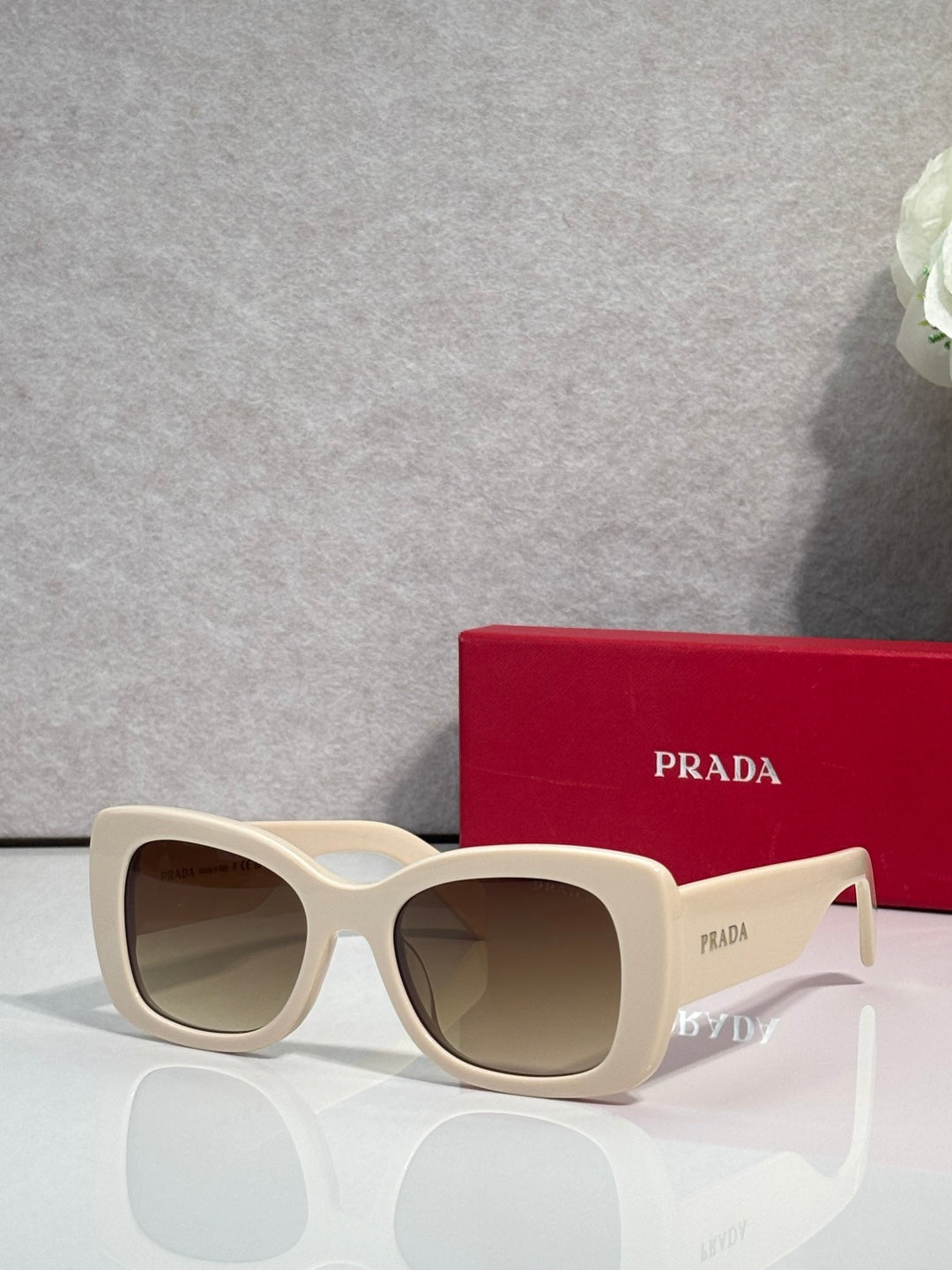 Prada square sunglasses with tan lenses and light cream frame