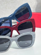 Prada square sunglasses stack with blue, red, and light-gray frames