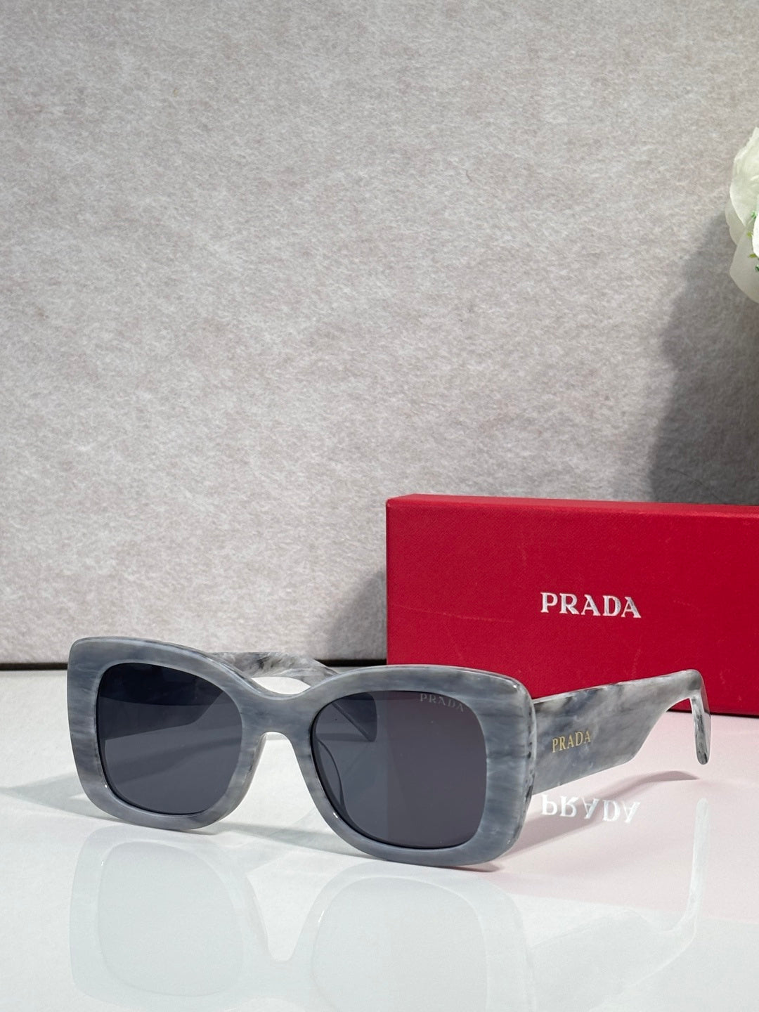 Prada square sunglasses with dark lenses and gray-blue frame