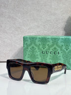 Gucci sunglasses with tortoiseshell square frames and amber lenses, gold Gucci logo on temple