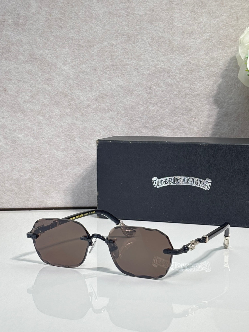 Chrome glasses with brown tinted lenses, gold details, and black temple arms