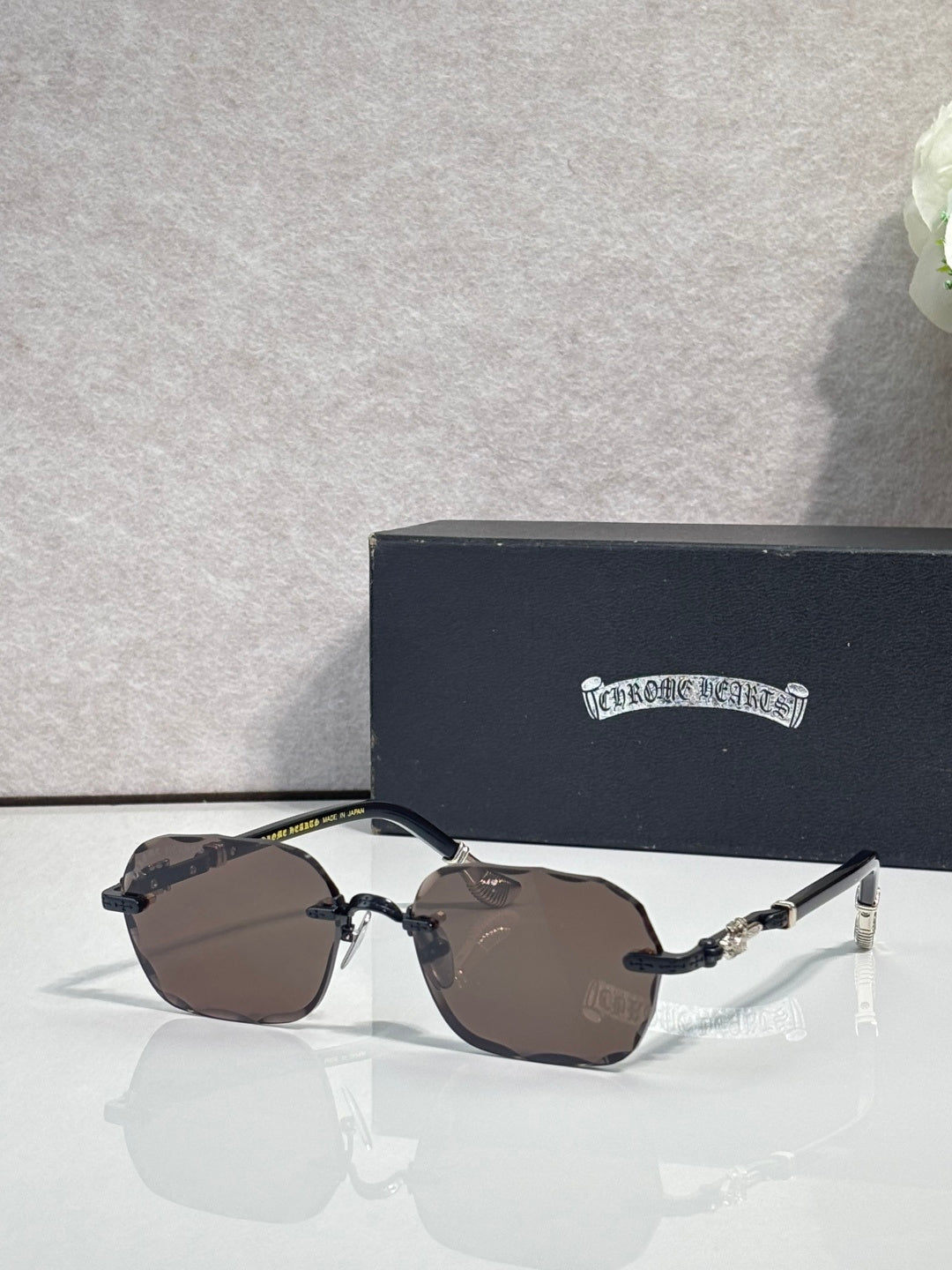 Chrome glasses with brown tinted lenses, gold details, and black temple arms