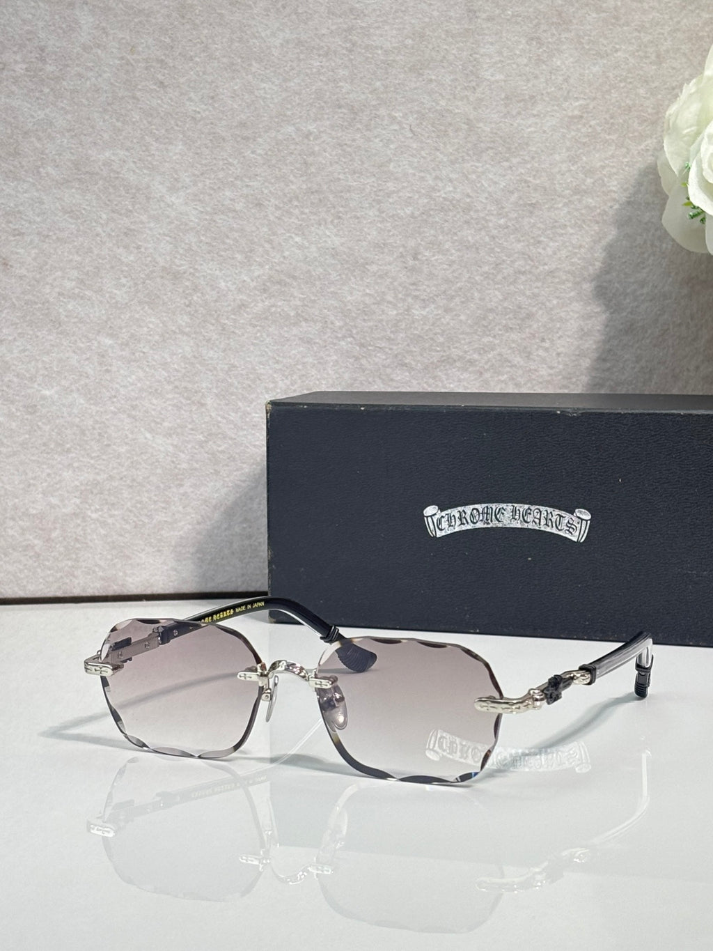 Chrome glasses with clear-to-gray lenses, gold accents, and patterned temple arms