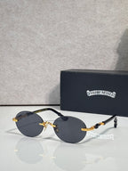 Round eyeglasses with dark lenses and gold accents on metal arms, with case