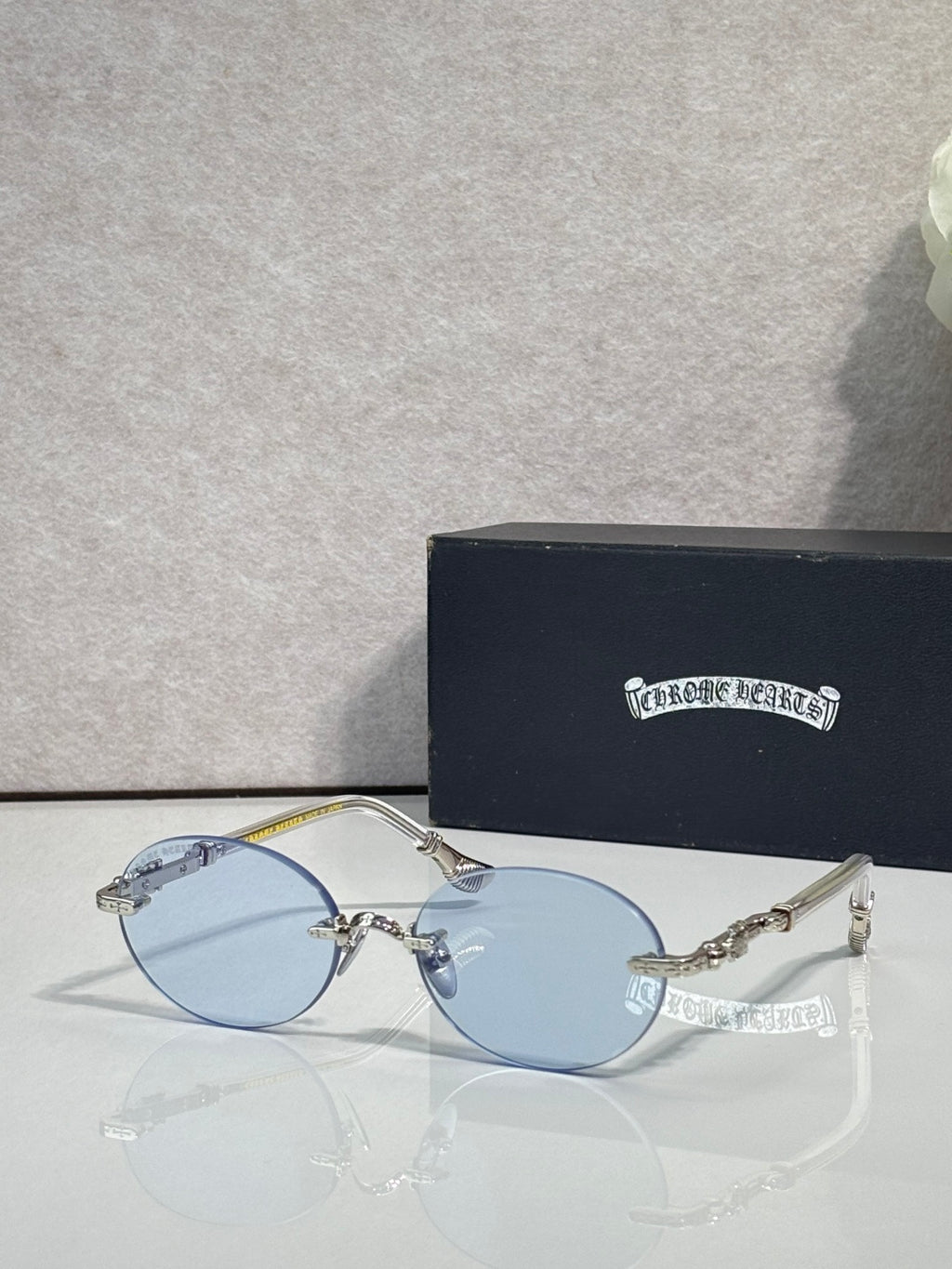 Round eyeglasses with light blue lenses and silver-tone frame, with case