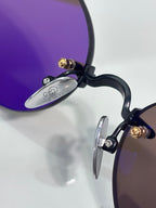 Close-up of eyeglass temple and metal hinge with gold and dark frame details