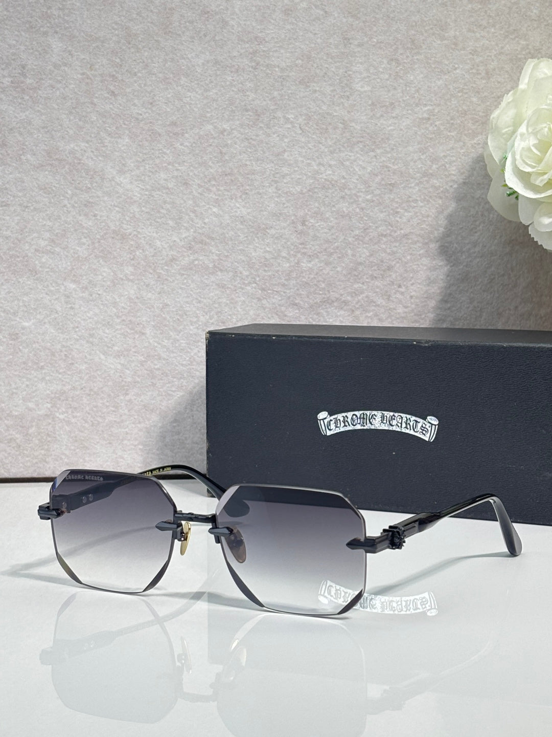 Chrome glasses with dark gray lenses, black frame, chrome arms with logo