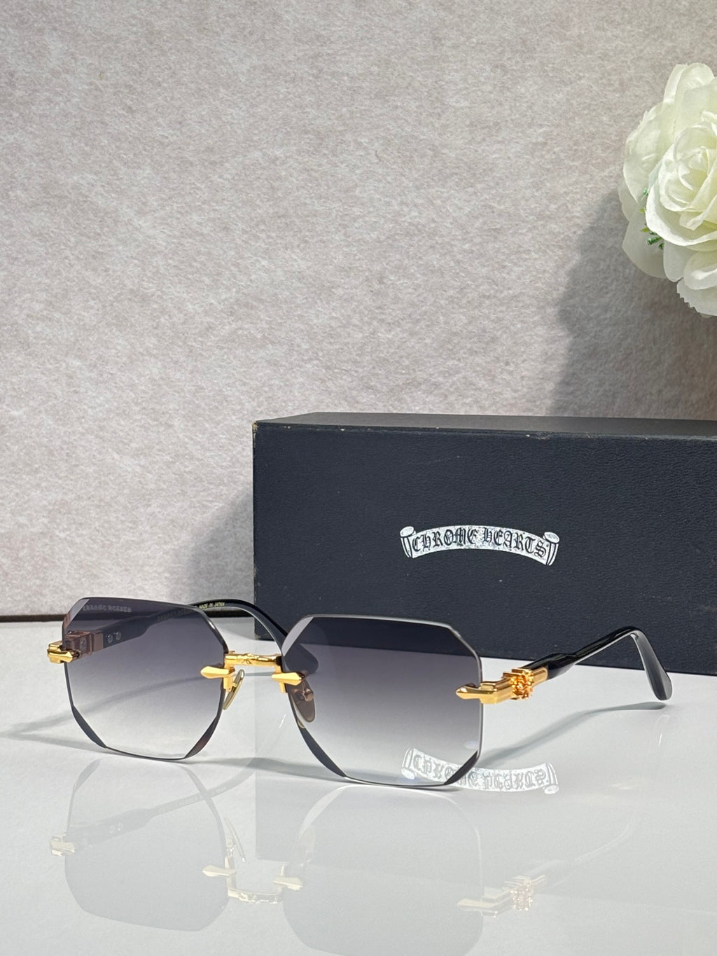 Chrome glasses with dark gray lenses, black frame, gold-tone arms and hinges