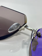 Chrome glasses close-up: silver temple hinge and purple-tinted lens edge