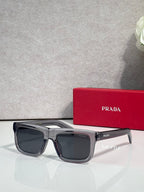 Prada sunglasses with gray rectangular frame and dark lenses, logo on arms.