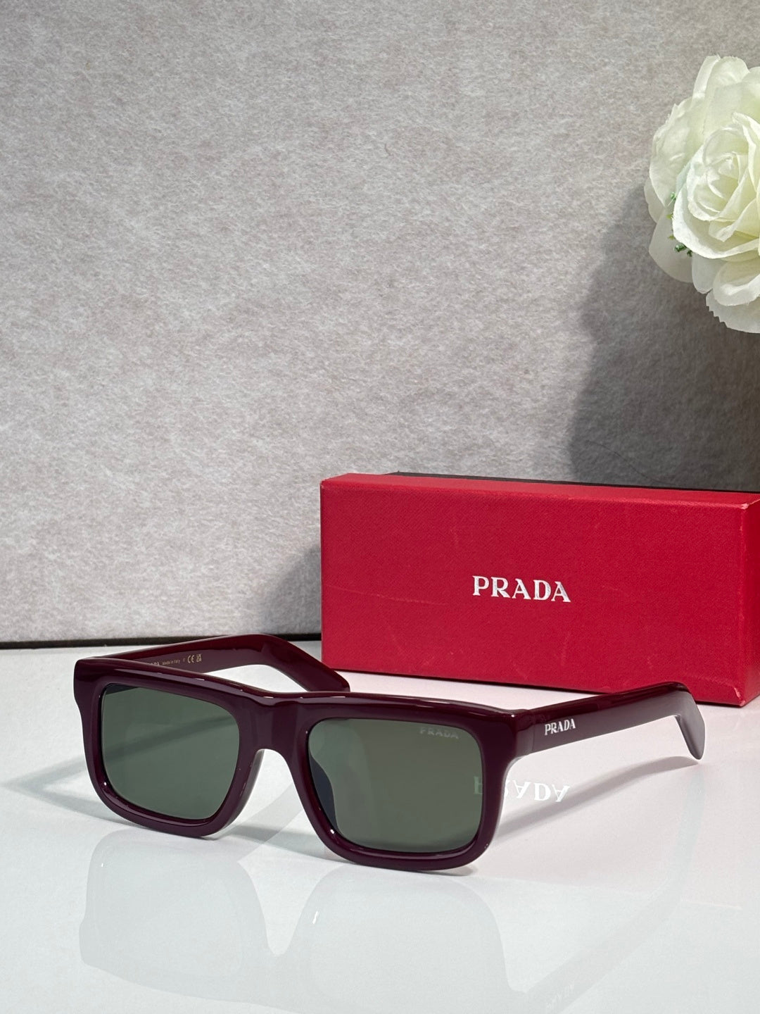 Prada glasses with burgundy frame and dark green lenses