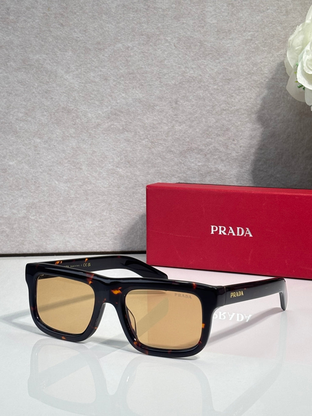 Prada glasses with black frame and amber-tan lenses