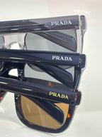 Prada glasses, layered side view with navy frames and amber lenses